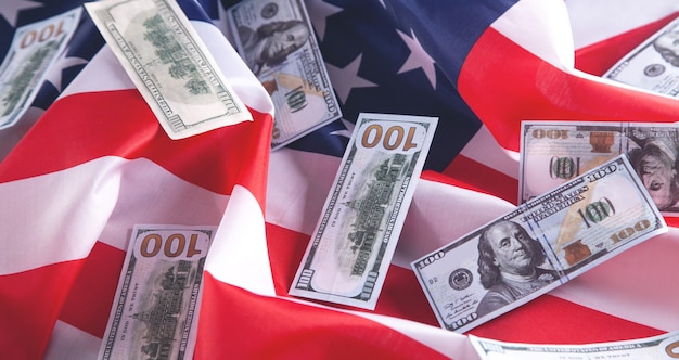 Dollar-Banknoten und USA-Nationalflagge.