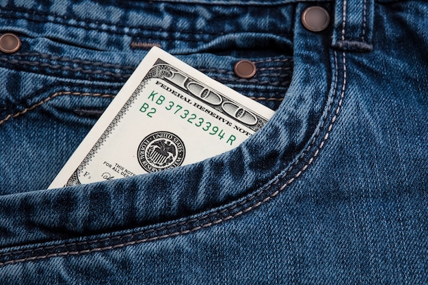 Dollar-Geldschein in einer Tasche mit Blue Jeans