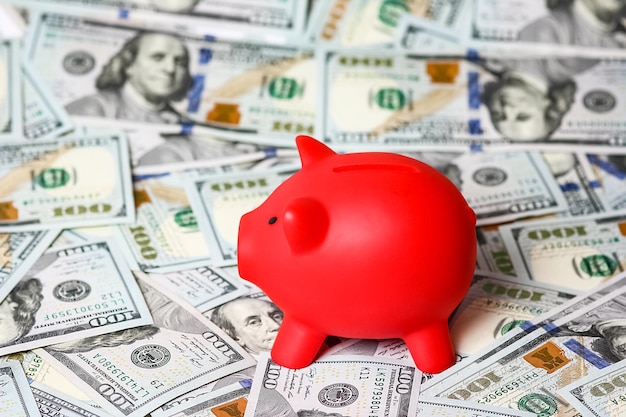 Dollar in Bündeln auf einem weißen Hintergrund mit einem Sparschwein Schweinedarlehen, um das Bankgeschäft zu retten Konz