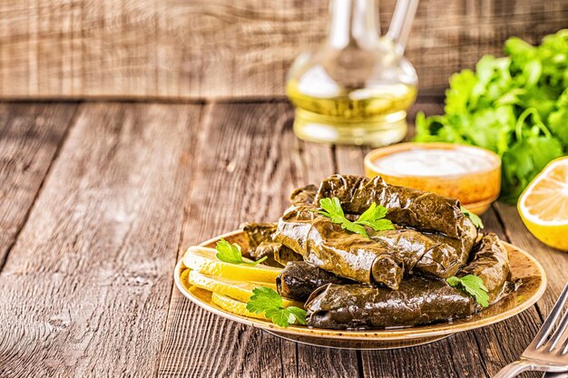 Dolma, hojas de parra rellenas con arroz y carne sobre fondo oscuro, enfoque selectivo.