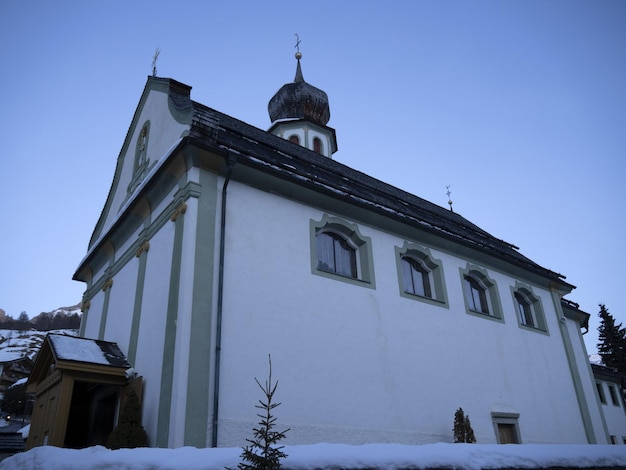 Dolomitas de la iglesia de San Cassiano en invierno al atardecer