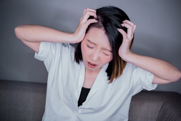 Dolor de cabeza dolor de cabeza de mano de mujer asiática Closeup toque