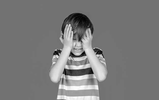 Foto dolor de cabeza niño dolor de cabeza debido al estrés retrato de un niño triste sosteniendo la cabeza con la mano