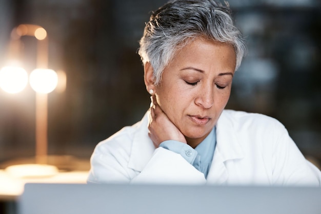 Dolor de cuello nocturno y agotamiento con el médico en la computadora portátil para el pensamiento médico y la revisión de la fecha límite Responsabilidad del estrés y salud mental con la mujer mayor para la medicina de la salud y la investigación científica