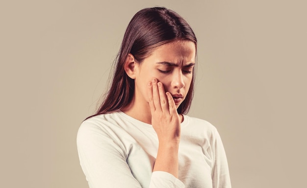 Dolor de dientes mujer hermosa toca su cara con la mano