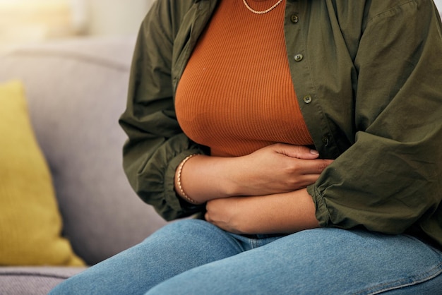 Dolor de estómago de mujer enferma y manos en el abdomen para la digestión del ibs y náuseas del virus del síndrome premenstrual o ansiedad Menstruación de una persona femenina o problema abdominal de estreñimiento salud intestinal o endometriosis