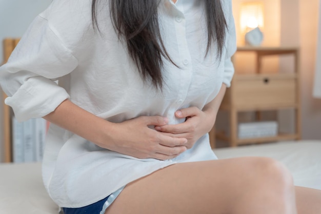 Dolor de estómago Las mujeres asiáticas tienen dolor abdominal indigestión gastritis calambres menstruales flatulencia diarrea distensión cáncer de colon inflamación del vientre problema sufren intoxicación alimentaria abdomen