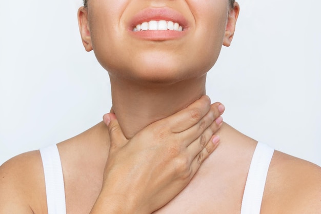 Foto dolor de garganta. captura recortada de una joven caucásica con dolor de garganta sosteniendo su cuello con la mano