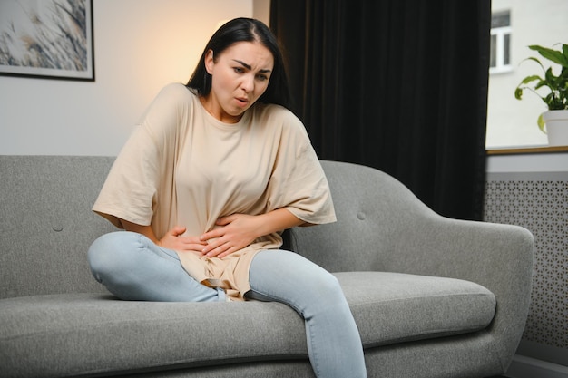 Dolor menstrual mujer con dolor de estómago que sufre de síndrome premenstrual en casa endometriosis cistitis y otras enfermedades del sistema urinario