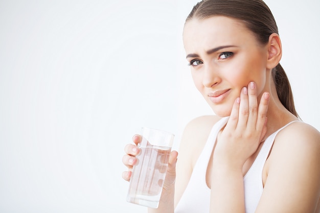 Dolor de muelas. Mujer sintiendo dolor de dientes. Primer de la muchacha triste hermosa que sufre de dolor de diente fuerte. Atractiva mujer sensación dolorosa dolor de muelas. Concepto de salud y cuidado dental