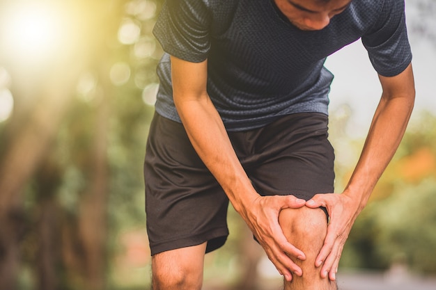 Dolor de rodilla del hombre corredor al correr