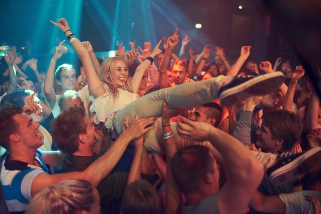 Domine a noite Foto recortada de uma multidão surfando em um festival de música