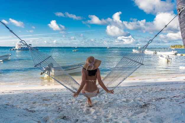 Dominikanische Republik Punta Cana ein Mädchen mit Hut am Meer mit türkisfarbenem Wasser und Palmen