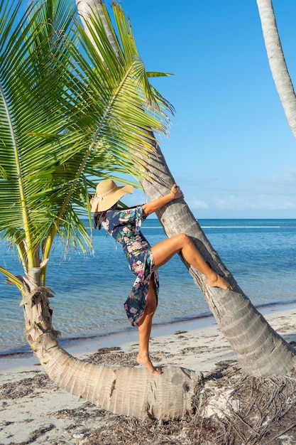 Dominikanische Republik Punta Cana ein Mädchen mit Hut am Meer mit türkisfarbenem Wasser und Palmen