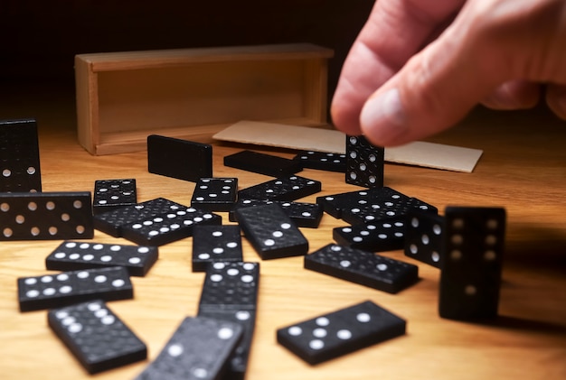 Domino-Spielsteine auf Holztisch mit Holzkiste verstreut