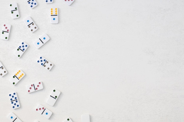 Dominoes blancos con puntos coloridos en un fondo de cemento blanco vista superior Juego de mesa