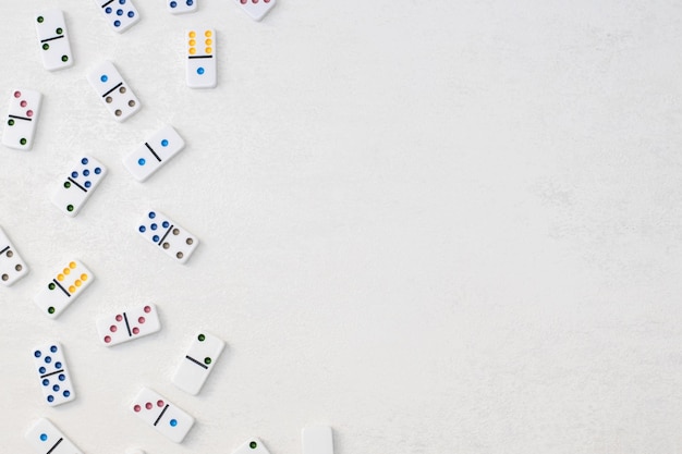 Dominós brancos com pontos coloridos em uma vista superior de fundo de cimento branco Jogo de tabuleiro