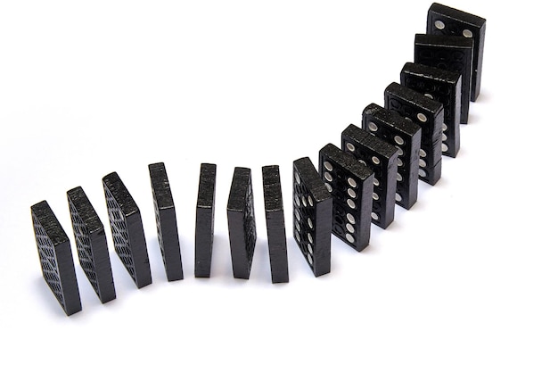 Foto dominós pretos em cadeia no fundo branco