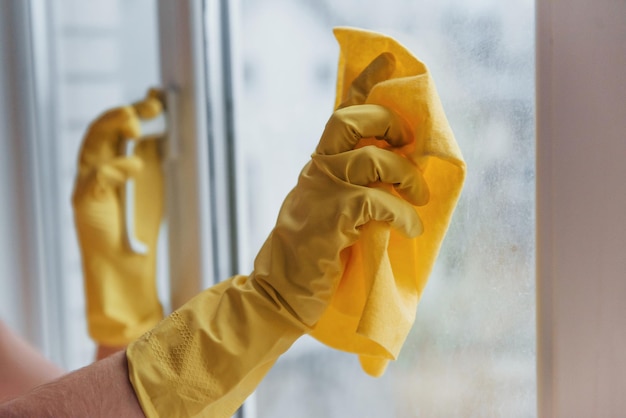 Dona de casa em uniforme amarelo limpando janelas Concepção de renovação de casa