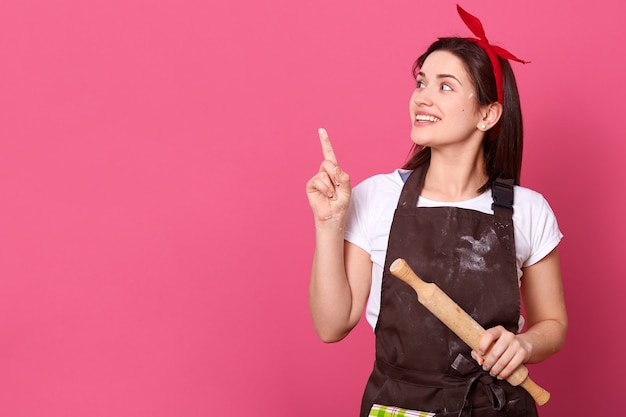 Dona de casa energética positiva, olhando de lado, fazendo gesto com o dedo indicador