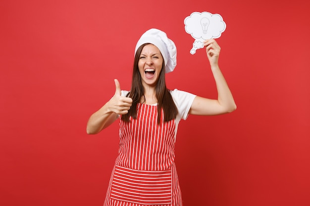 Foto dona de casa feminina chef cozinheira ou padeiro no chapéu de chefs avental listrado branco t-shirt toque isolado no fundo da parede vermelha. mulher divertida dona de casa segurar, digamos, nuvem com a ideia de lâmpada. simule o conceito de espaço de cópia