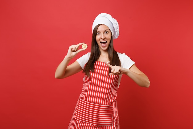 Dona de casa feminina chef cozinheira ou padeiro no chapéu de chefs avental listrado branco t-shirt toque isolado no fundo da parede vermelha. Mulher sorridente segurando bitcoin, bit moeda futura moeda. Mock-se o conceito de espaço de cópia.