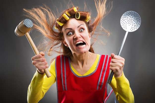 Foto dona de casa louca com utensílios de cozinha