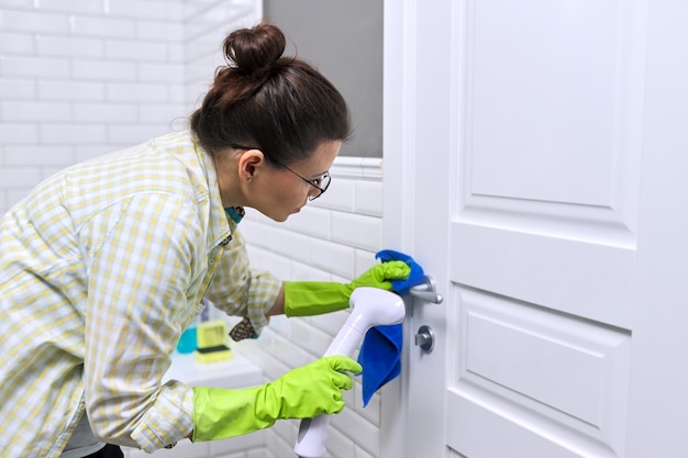 Dona de casa mulher fazendo a limpeza da casa no banheiro, porta de lavagem feminina com chuveiro de vapor. Usando limpador a vapor para limpeza rápida