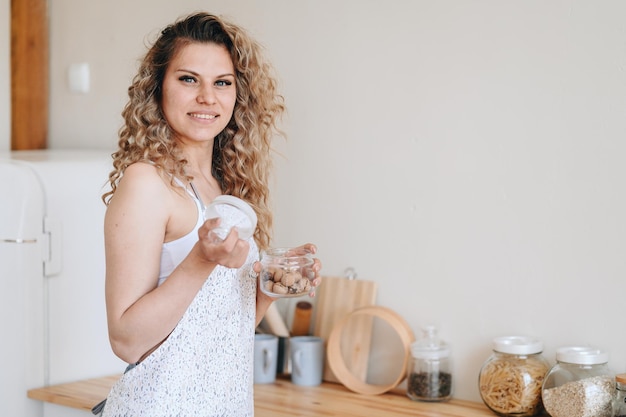 Dona de casa na cozinha de avental se prepara para comer