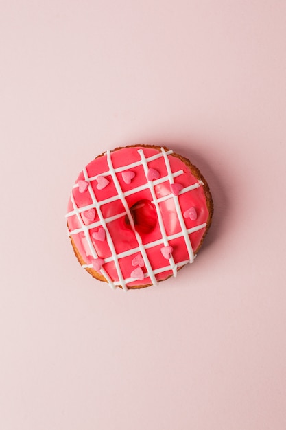 Una dona rosa colar viva con forma de corazón asperja sobre fondo rosa, monocromo