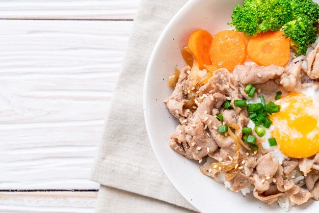 Donburi, tazón de arroz de cerdo con huevo onsen y vegetales