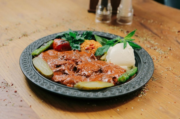 Doner kebab está deitado na tábua. Shawarma com carne, cebola, salada encontra-se em uma madeira velha escura