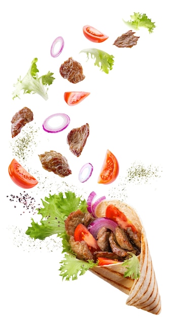 Doner kebab o shawarma con ingredientes flotando en el aire: carne de res, lechuga, cebolla, tomate, especias.