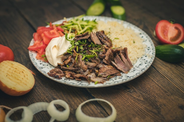 Doner o shawarma llamado pilav ustu sobre arroz con yogur, tomates y hierbas