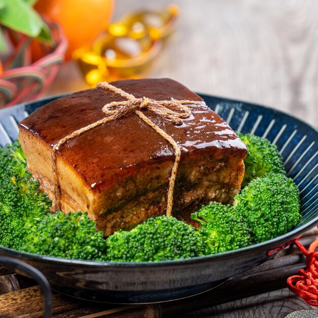 Dong po rou carne de porco dongpo em um lindo prato azul com brócolis verde vegetal tradicional comida festiva para refeição de cozinha de ano novo chinês close up