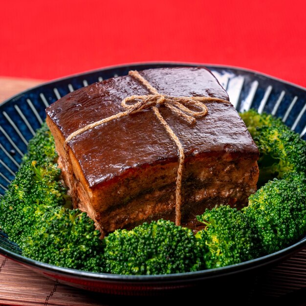 Dong Po Rou Carne de porco Dongpo em um lindo prato azul com brócolis verde vegetal tradicional comida festiva para refeição de cozinha de ano novo chinês close up