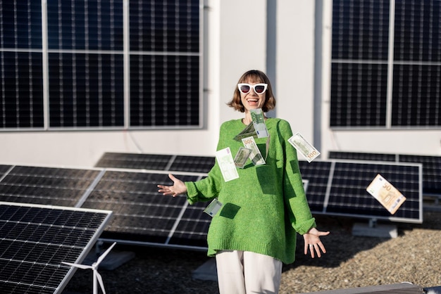 Dono de família feliz com dinheiro perto de usina de energia solar