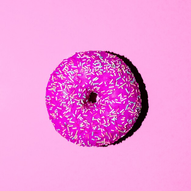 Donut auf rosa Hintergrund. Minimal. Surreale Modekunst