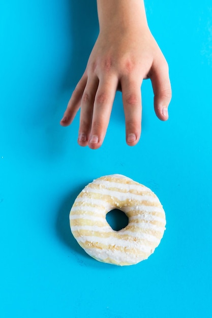 Donut con avellanas sobre fondo azul de cerca