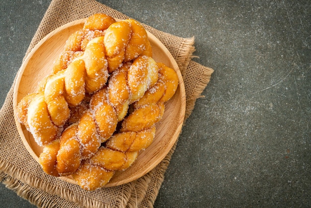 donut de azúcar en forma de espiral sobre placa de madera