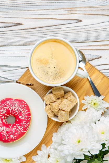 Donut y café sobre fondo de madera