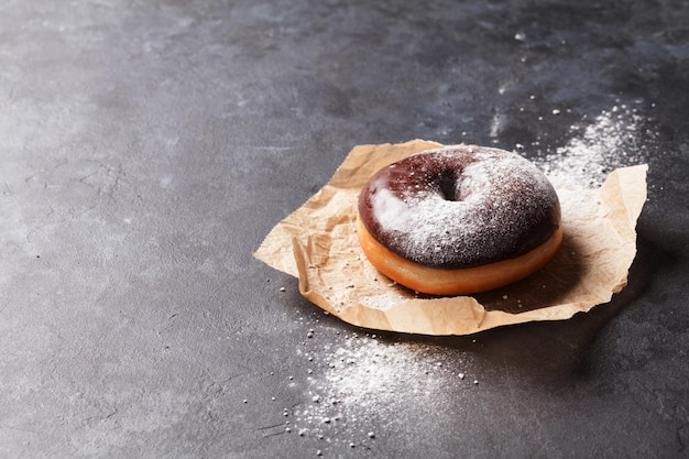 Donut de chocolate con azúcar en polvo