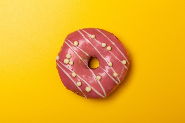 Donut de ciruela fresa sobre fondo amarillo