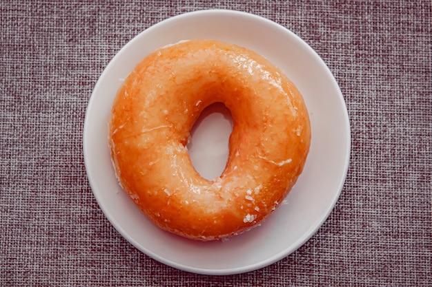 Donut com açúcar em uma placa de cor branca, Donut toppint com açúcar.