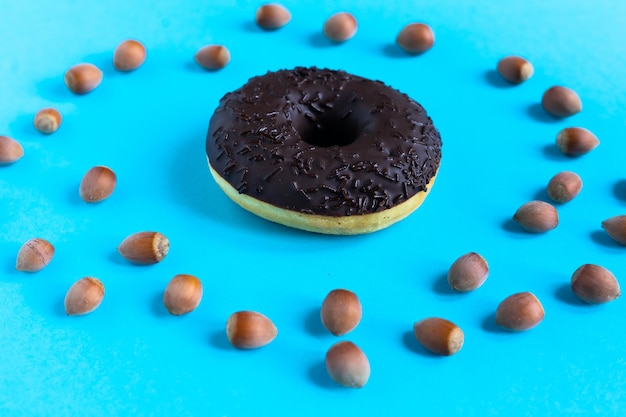 Donut com avelãs em fundo azul, close-up