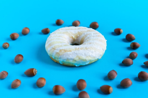 Donut com avelãs em fundo azul, close-up