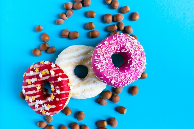 Donut com avelãs sobre fundo azul close-up