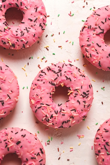 Donut com morangos em decoração de confeitaria de esmalte rosa vista superior