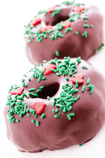 Donut cubierto de chocolate gourmet decorado como una corona navideña.