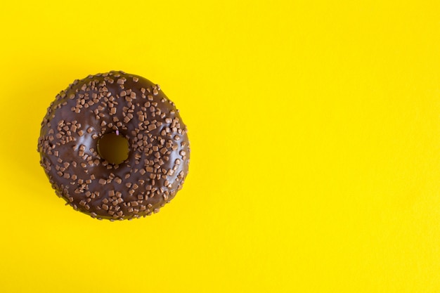 Donut de chocolate no fundo amarelo